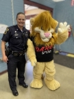 Officer Rachael Lacombe in unform standing with the DARE Mascot